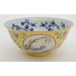 A CHINESE MEDALLION YELLOW GROUND BOWL painted with panels of goats, divided by precious objects,
