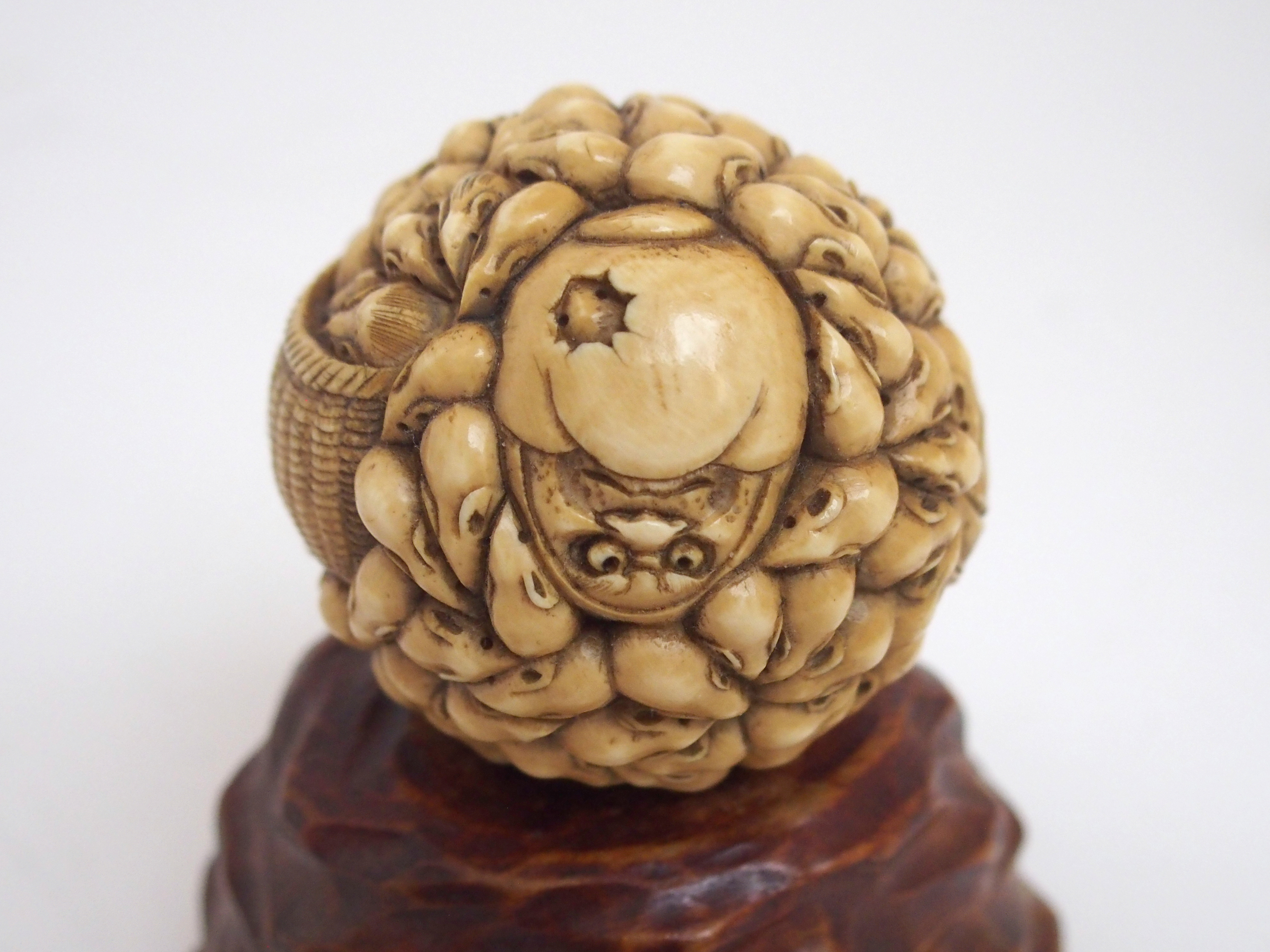 A JAPANESE IVORY OVAL MASK BOX AND COVER carved with many face masks, the cover with mask finial, - Image 2 of 14