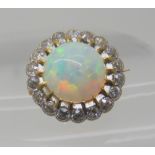 AN OPAL AND DIAMOND BROOCH opal approx 10.4mm in diameter, surrounded with a row of diamonds which