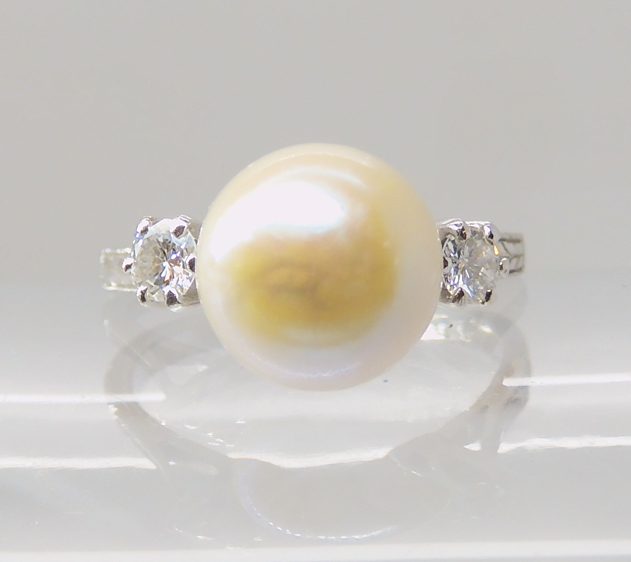 AN 18CT WHITE GOLD PEARL AND DIAMOND RING with wreath engraved shoulders, pearl approx 9mm in