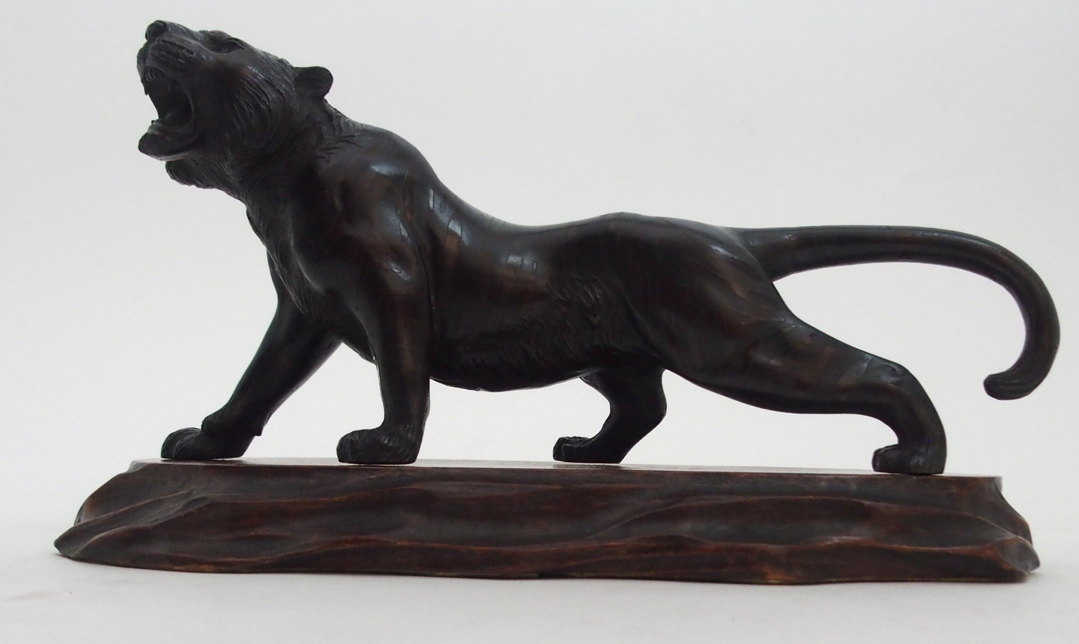 A JAPANESE BRONZE MODEL OF A TIGER prowling on all fours, signed, 11.5cm high and 24cm long, wood