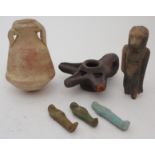 AN EGYPTIAN OIL VESSEL 12cm high, oil lamp, 13cm wide and four shabti, 6, 7, 7.5 and 12cm high (6)