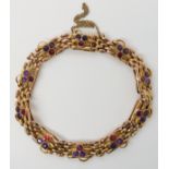 A 9CT GOLD GARNET AND AMETHYST EDWARDIAN BRACELET with garnet and amethyst flowers set to every
