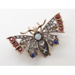 A YELLOW AND WHITE METAL DIAMOND AND GEM SET BUTTERFLY BROOCH with pierced wings, set with rubies,