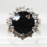 A SAPPHIRE AND DIAMOND FLOWER CLUSTER RING mounted throughout in unhallmarked white metal. The