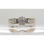A 9CT GOLD DIAMOND FLOWER RING set with estimated approx 0.80cts of brilliant cut diamonds. Finger