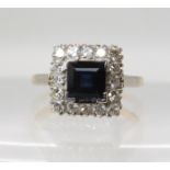AN 18CT GOLD AND PLATINUM SAPPHIRE AND DIAMOND RING set with a square cut sapphire surrounded with