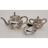 A CHINESE EXPORT SILVER THREE PIECE TEA SERVICE cast with dragons chasing the flaming pearl, with