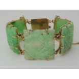 A 9CT GOLD MOUNTED CHINESE GREEN HARDSTONE BRACELET the central panel is pierced as well as carved