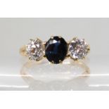 A BRIGHT YELLOW METAL SAPPHIRE AND DIAMOND THREE STONE RING set with two diamonds with an