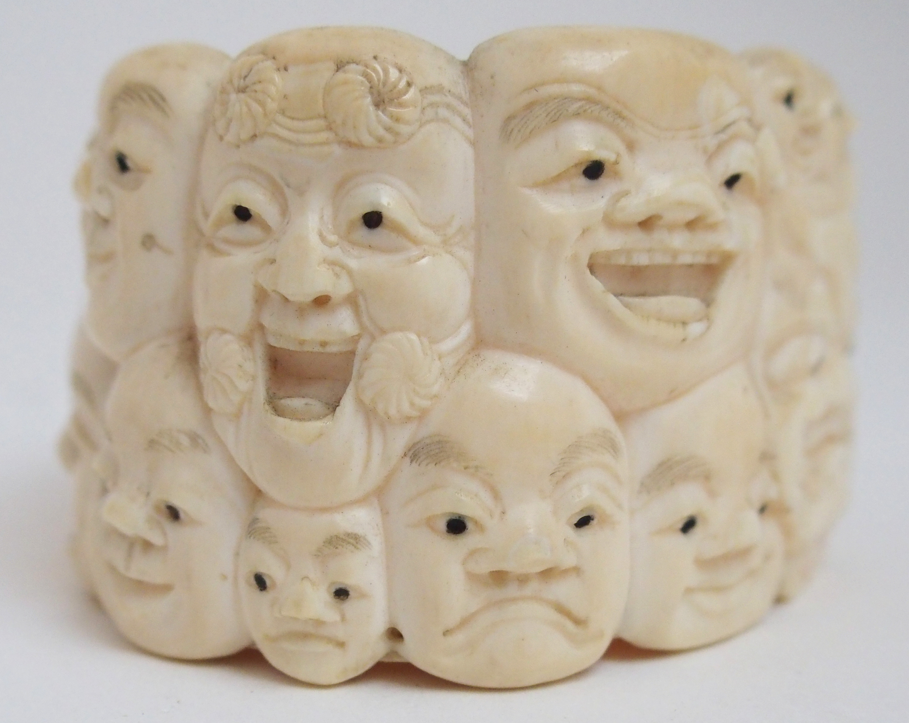 A JAPANESE IVORY OVAL MASK BOX AND COVER carved with many face masks, the cover with mask finial, - Image 14 of 14