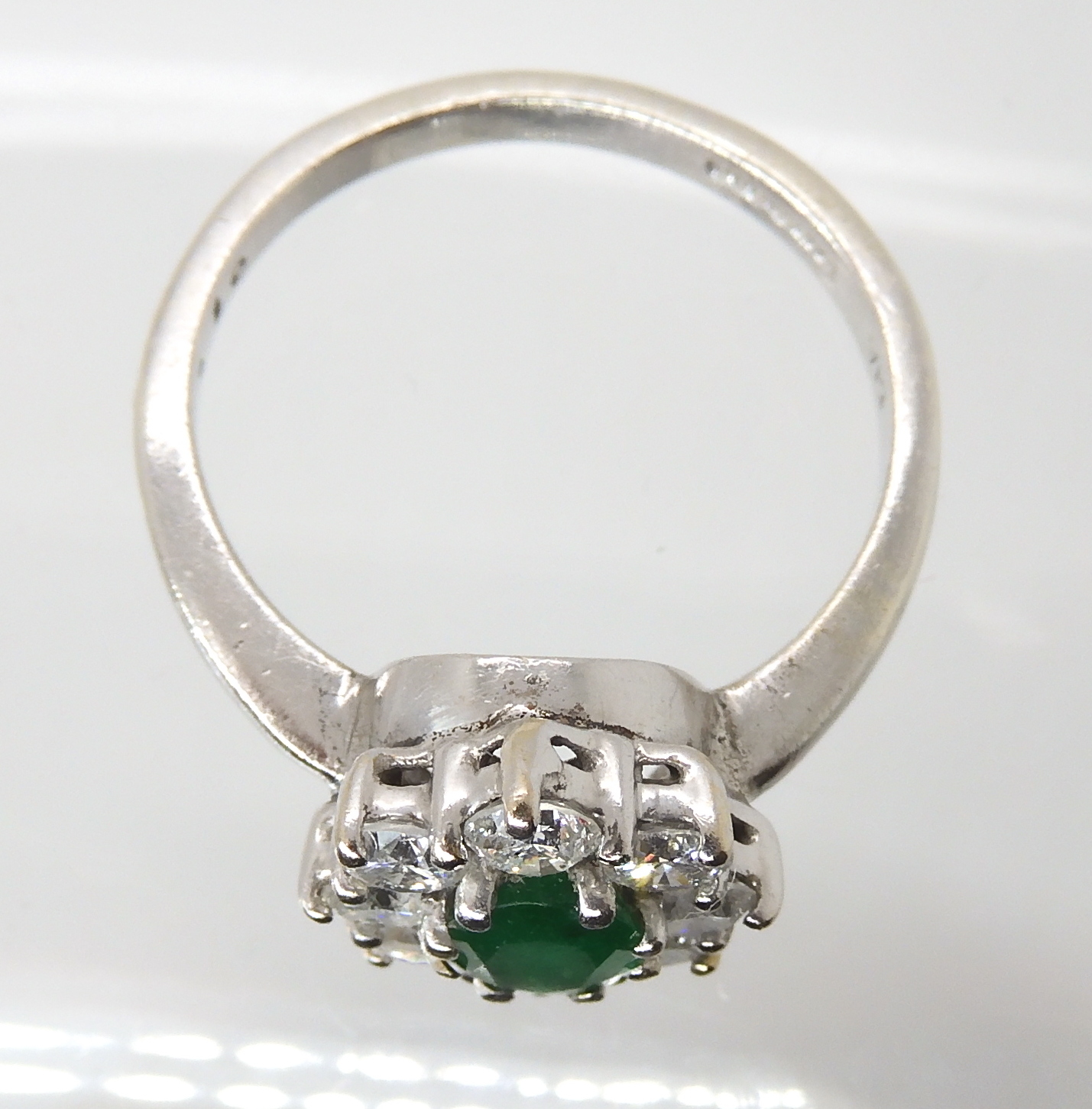 A 9CT WHITE GOLD EMERALD AND DIAMOND CLUSTER RING set with an oval emerald of approx 7mm x 5mm x 3. - Image 2 of 3
