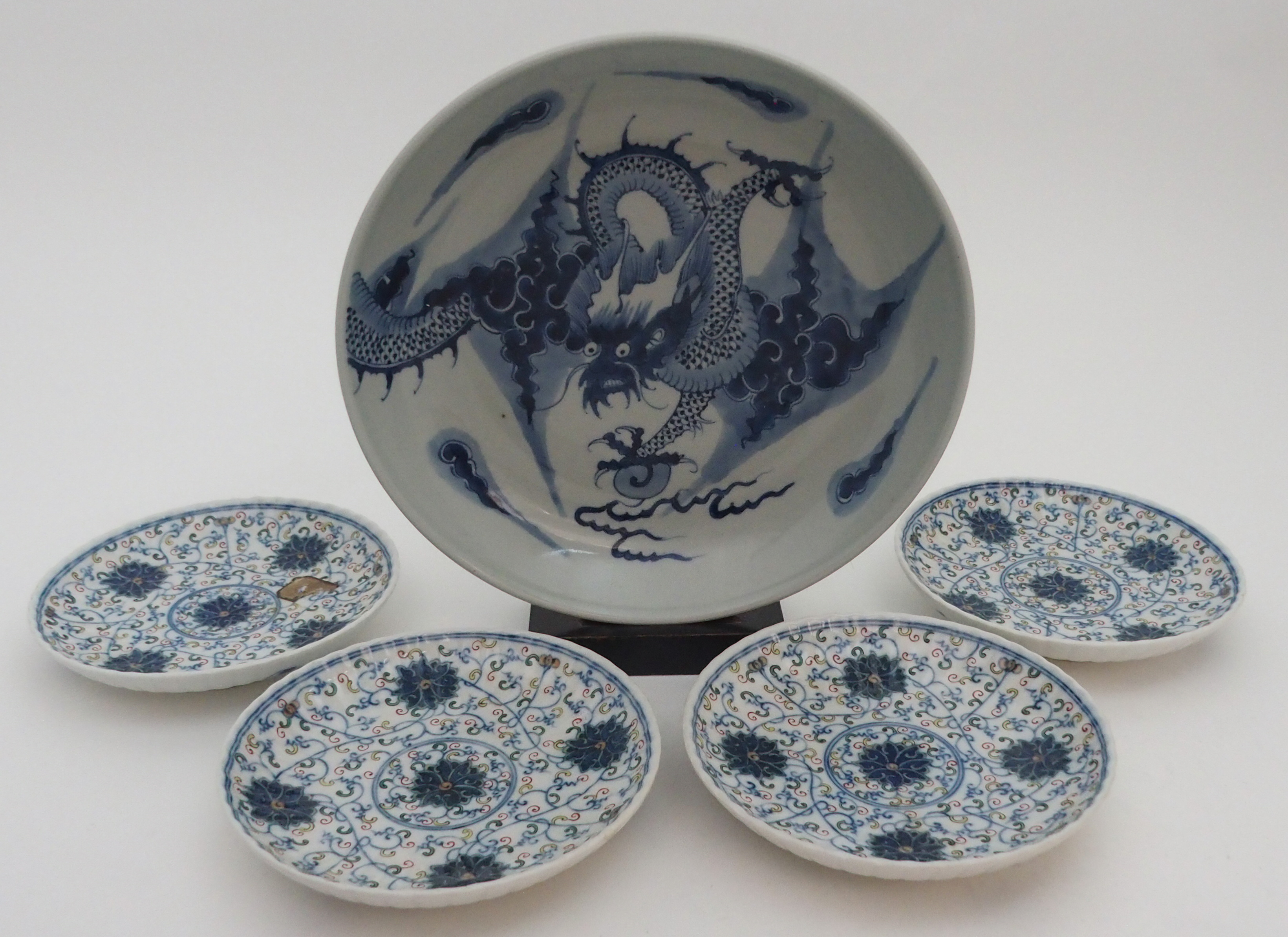 A CHINESE BLUE AND WHITE DISH painted with a dragon chasing the pearl of wisdom, 28cm diameter and