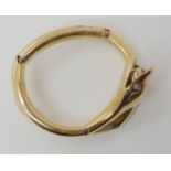 A YELLOW METAL VICTORIAN ARTICULATED SNAKE BANGLE with diamond set eyes, max size without loosing