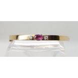 A 9CT GOLD PINK SAPPHIRE AND CUBIC ZIRCONIA BANGLE the pink sapphire is approx 7mm x 4.6mm x 3.