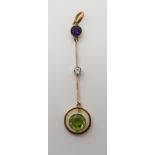 A YELLOW METAL EDWARDIAN DROP PENDANT set with a peridot, diamond (estimated approx 0.10cts) and