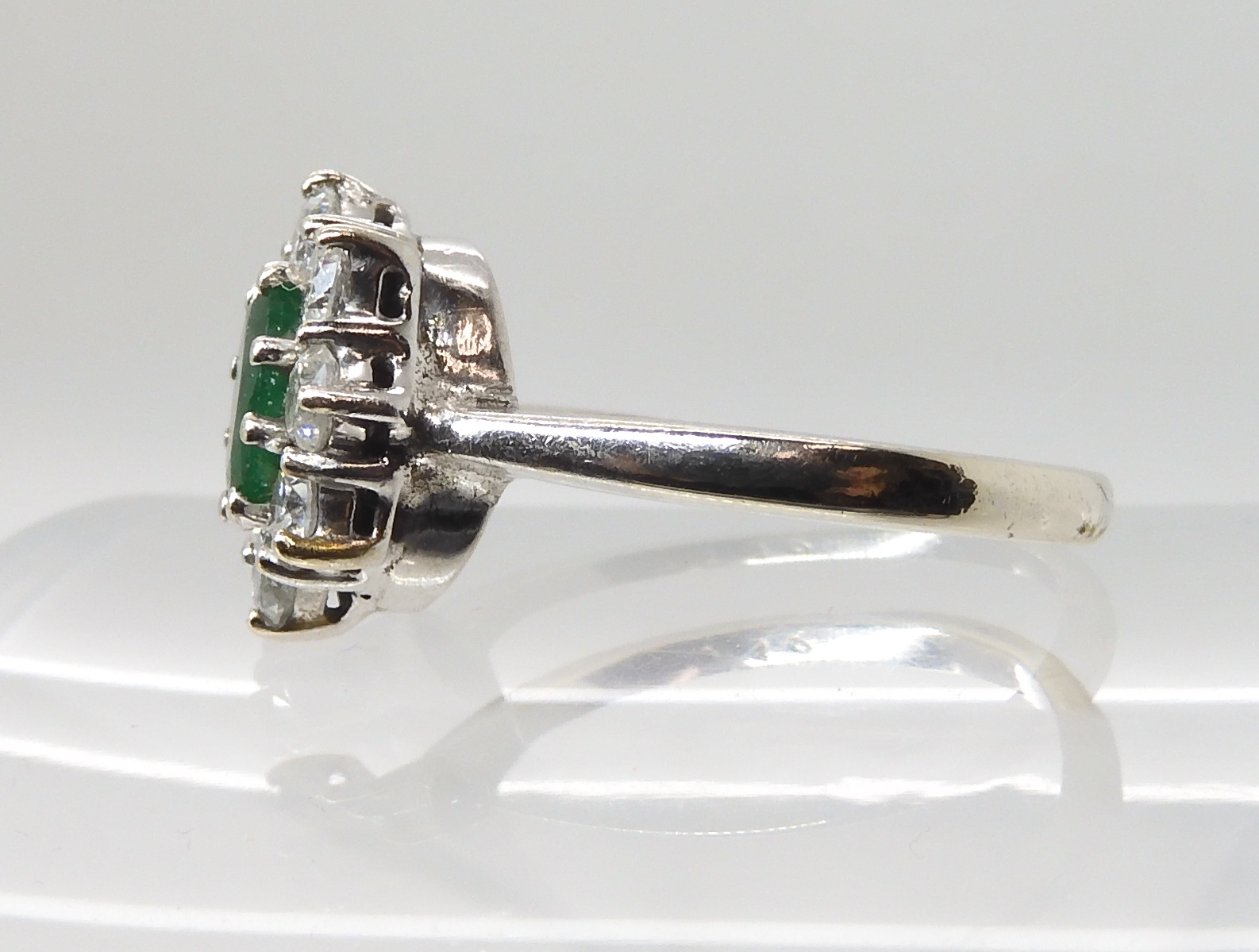 A 9CT WHITE GOLD EMERALD AND DIAMOND CLUSTER RING set with an oval emerald of approx 7mm x 5mm x 3. - Image 3 of 3