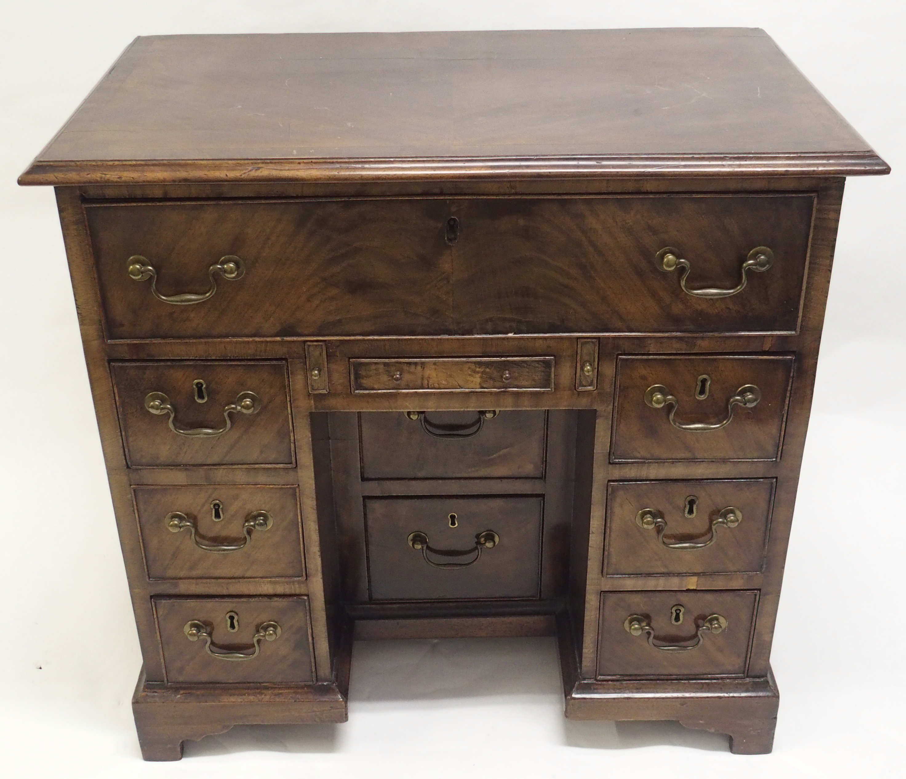 A GEORGE III STYLE MAHOGANY KNEEHOLE DESK with deep drawer above a shallow drawer and flanked by two