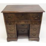 A GEORGE III STYLE MAHOGANY KNEEHOLE DESK with deep drawer above a shallow drawer and flanked by two