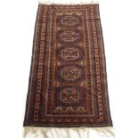 A DARK GROUND EASTERN RUG with five central lozenges, 190cm x 100cm Condition Report: Available upon