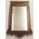 A GEORGIAN STYLE WALNUT AND GILT FRAMED MIRROR with egg and dart moulding above a foliate swept