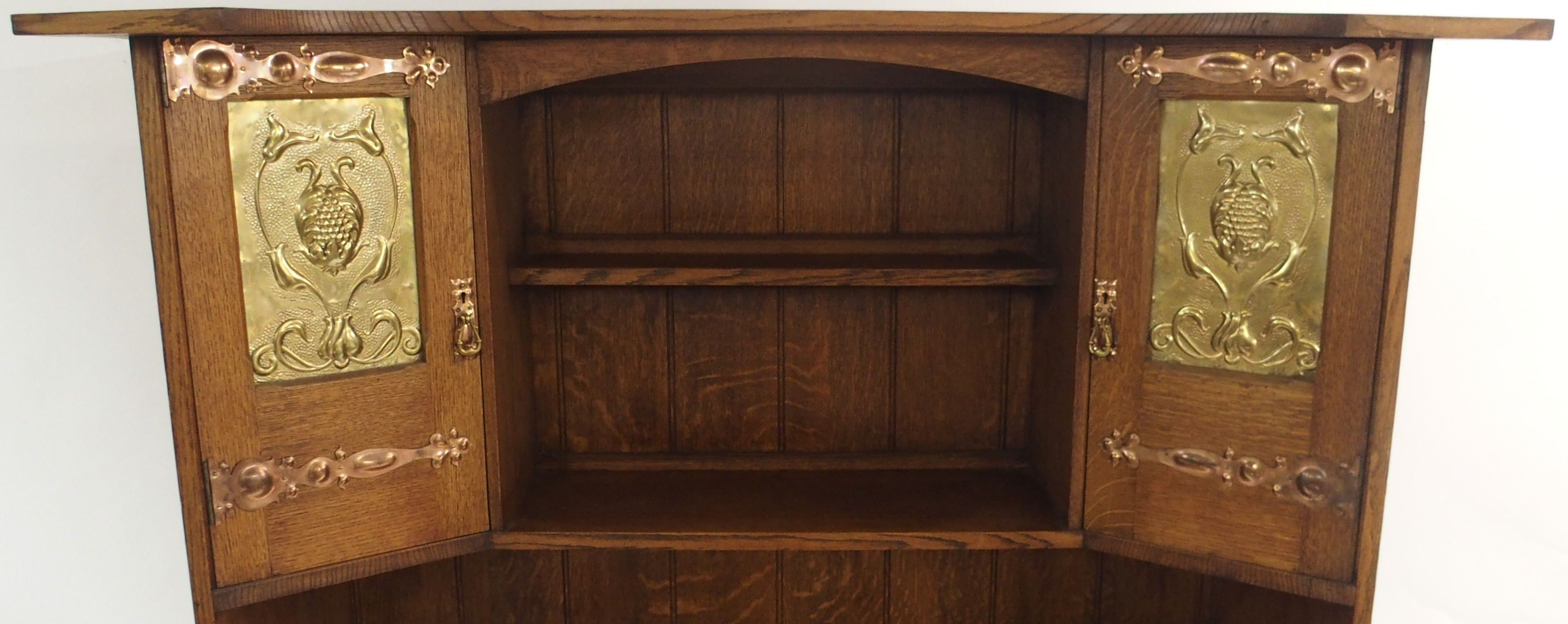 AN ARTS AND CRAFTS OAK DRESSER with open shelves, flanked by embossed inset brass panels and - Image 4 of 15