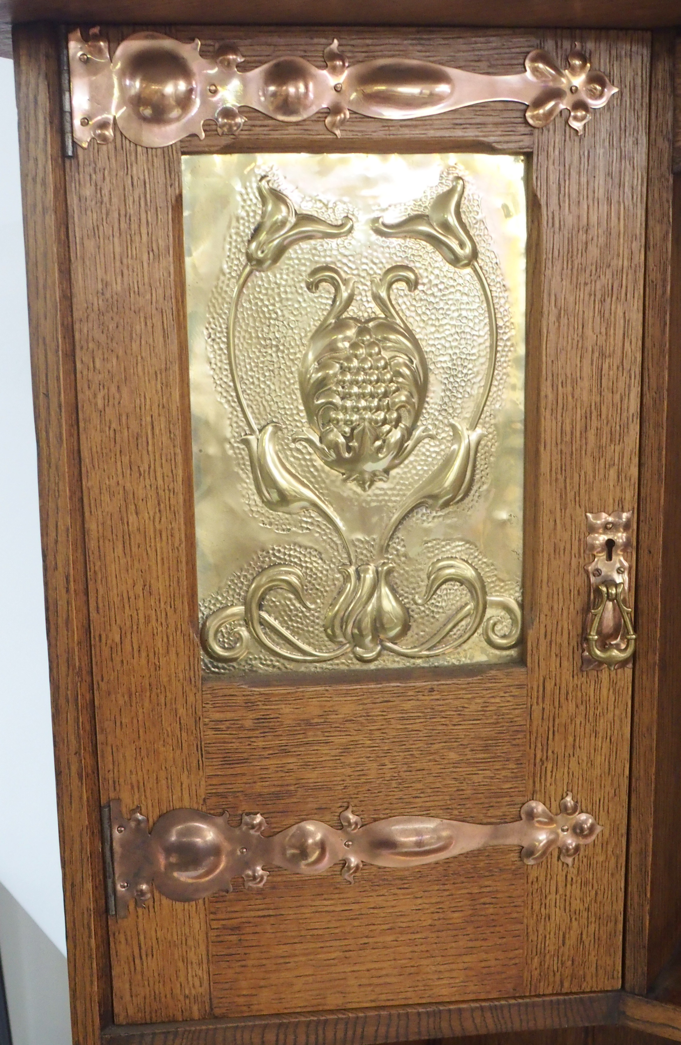 AN ARTS AND CRAFTS OAK DRESSER with open shelves, flanked by embossed inset brass panels and - Image 2 of 15