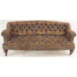 A VICTORIAN UPHOLSTERED BUTTON BACK SETTEE with walnut front ring turned legs and splayed back legs,