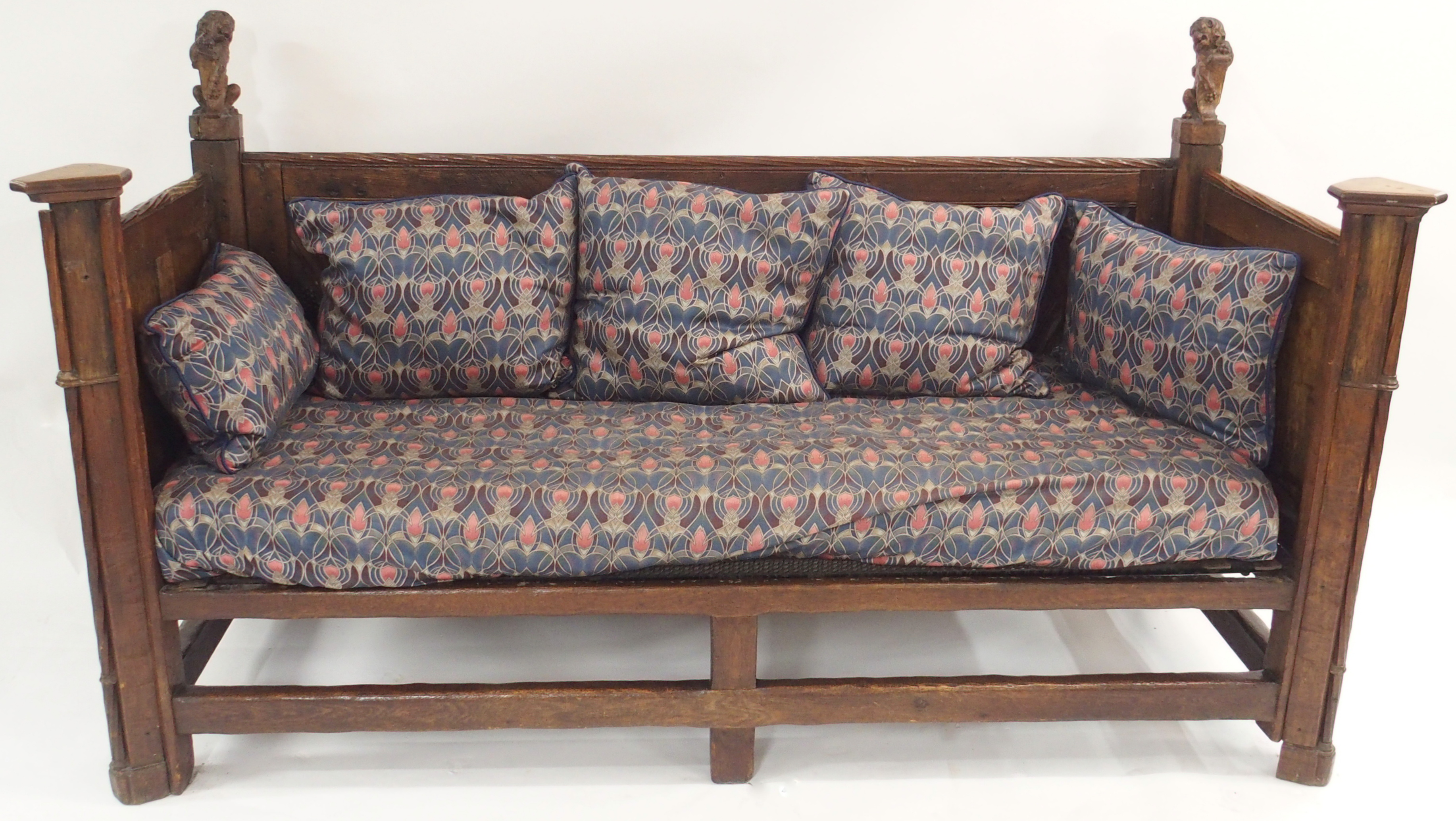 A FRENCH OAK GOTHIC STYLE DAY BED the panels carved with grape vines, chalice,cup and acorns beneath