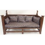 A FRENCH OAK GOTHIC STYLE DAY BED the panels carved with grape vines, chalice,cup and acorns beneath