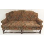 AN EDWARDIAN HUMPBACK SETTEE with woolwork upholstery decorated with animals and birds, on spiral