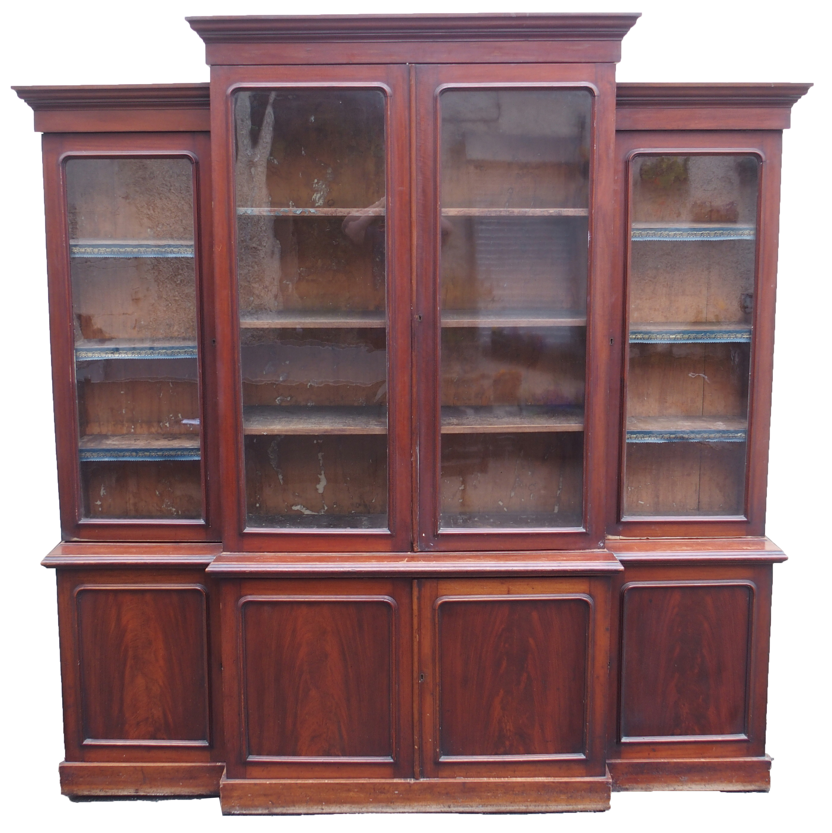 A VICTORIAN MAHOGANY BREAK FRONT BOOKCASE, with four glazed doors over a base with four doors, 231cm