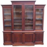 A VICTORIAN MAHOGANY BREAK FRONT BOOKCASE, with four glazed doors over a base with four doors, 231cm