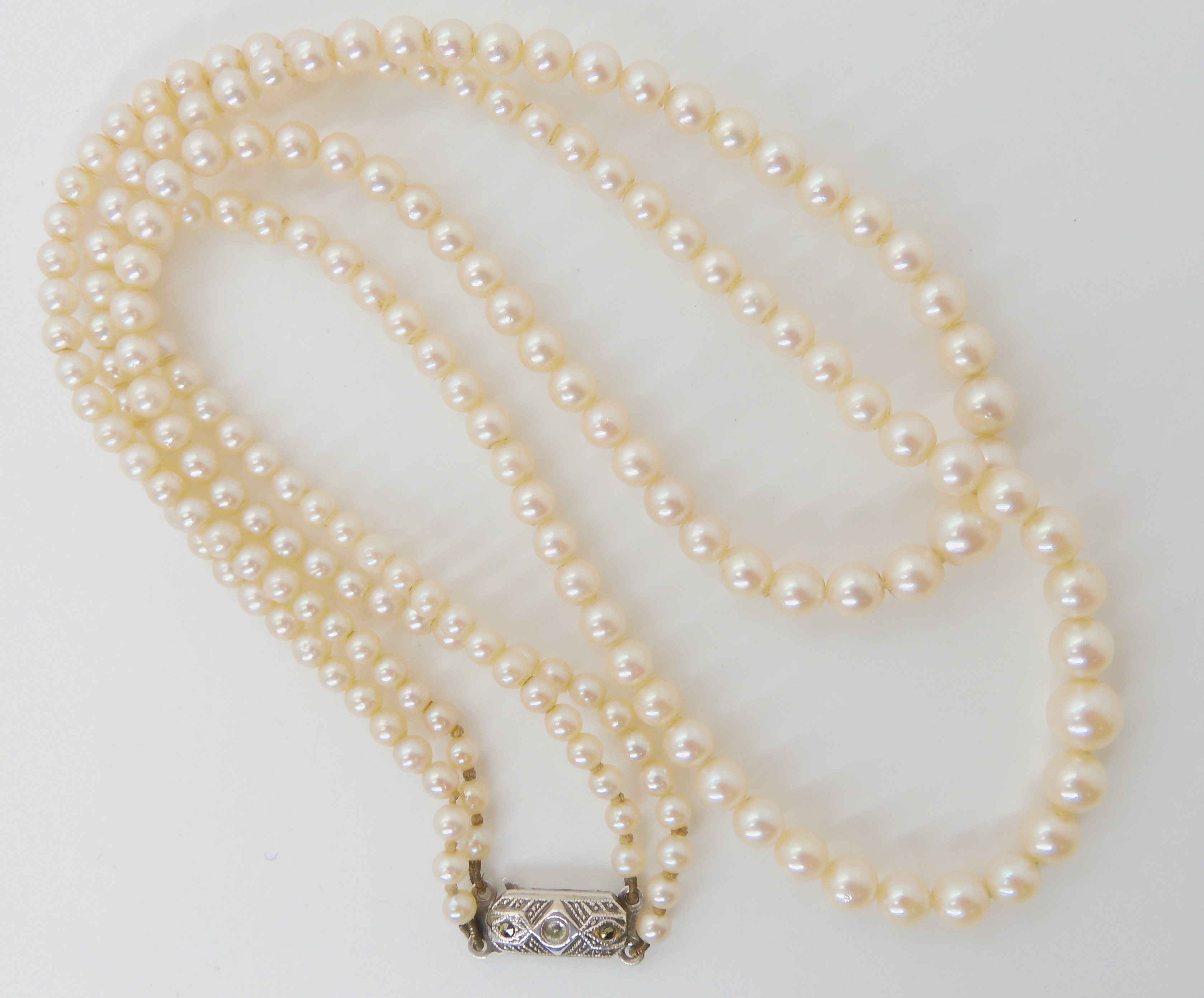 A double string of Mikimoto pearls with a silver Mikimoto stamped clasp, shortest length 43cm,