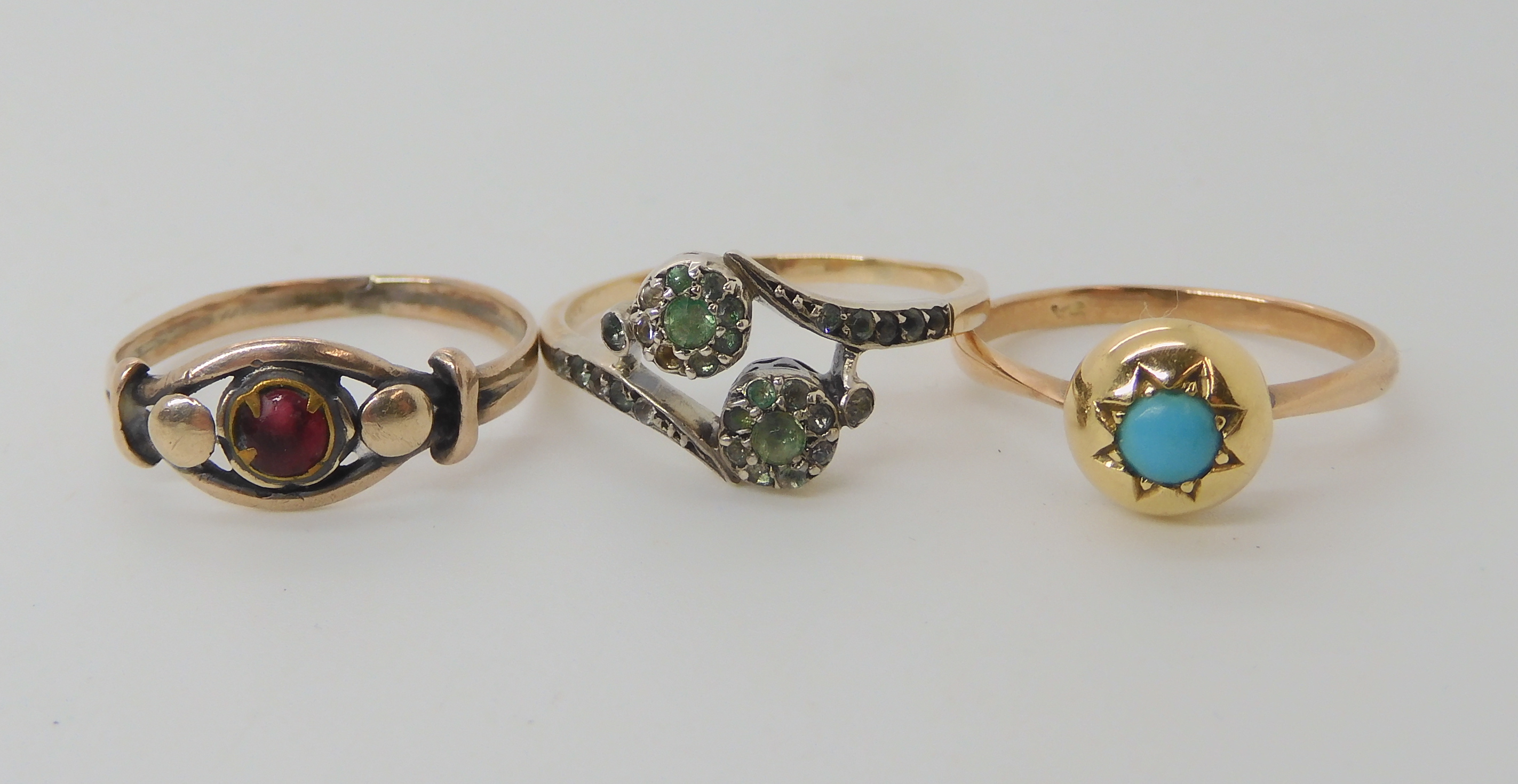 A 9ct turquoise set ring, size M1/2, a yellow metal double flower clear gem set ring size R and a