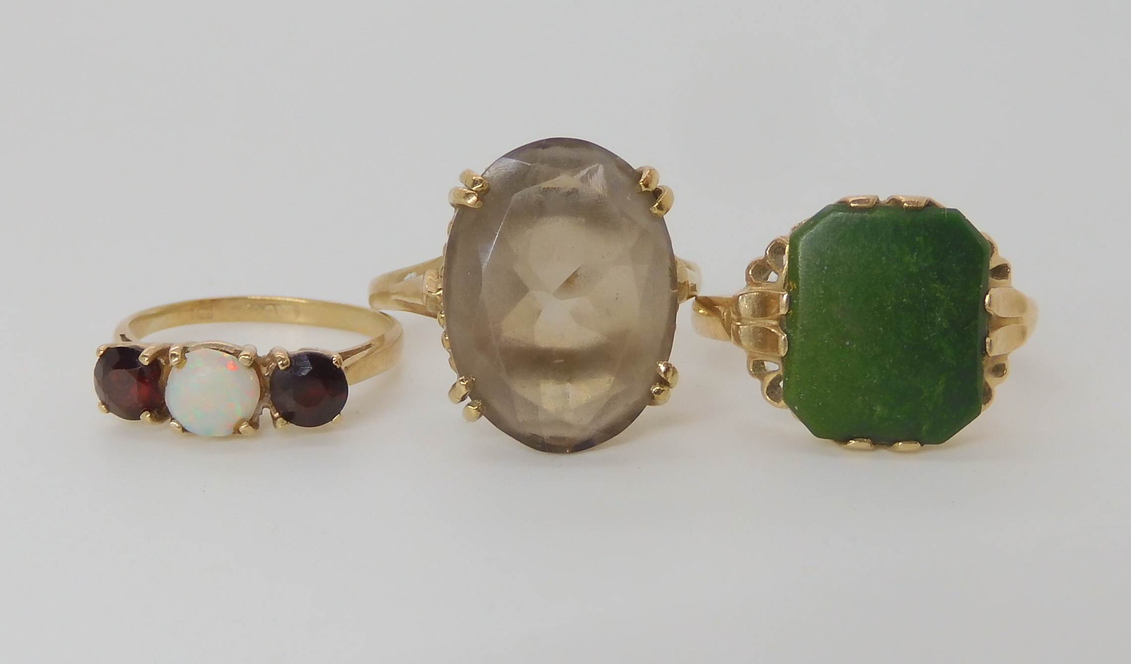 A 10k gold ring set with a green gemstone size M1/2, a 9ct smoky quartz style ring size N1/2 and a