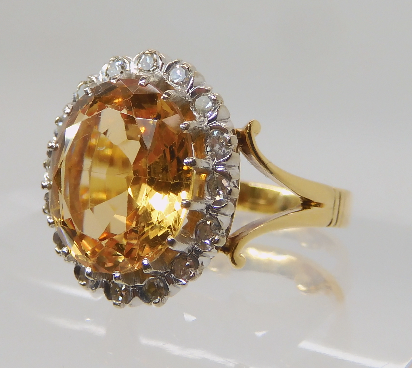 A bright yellow metal ring set with a yellow topaz surrounded with a ring of eight cut diamonds, - Image 2 of 4