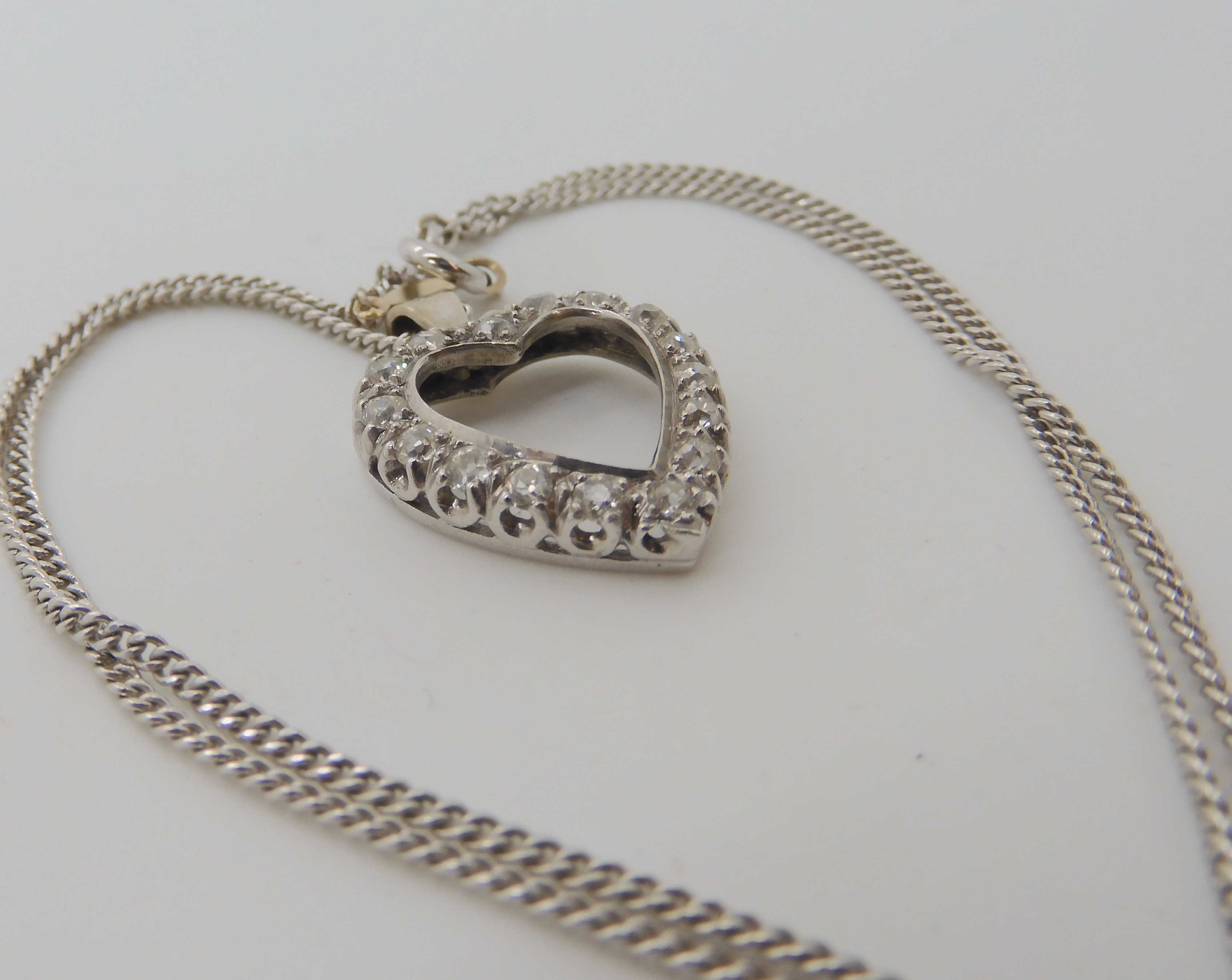 A white metal diamond set heart shaped pendant, dimensions 2.4cm x 1.8cm, set with estimated - Image 2 of 3