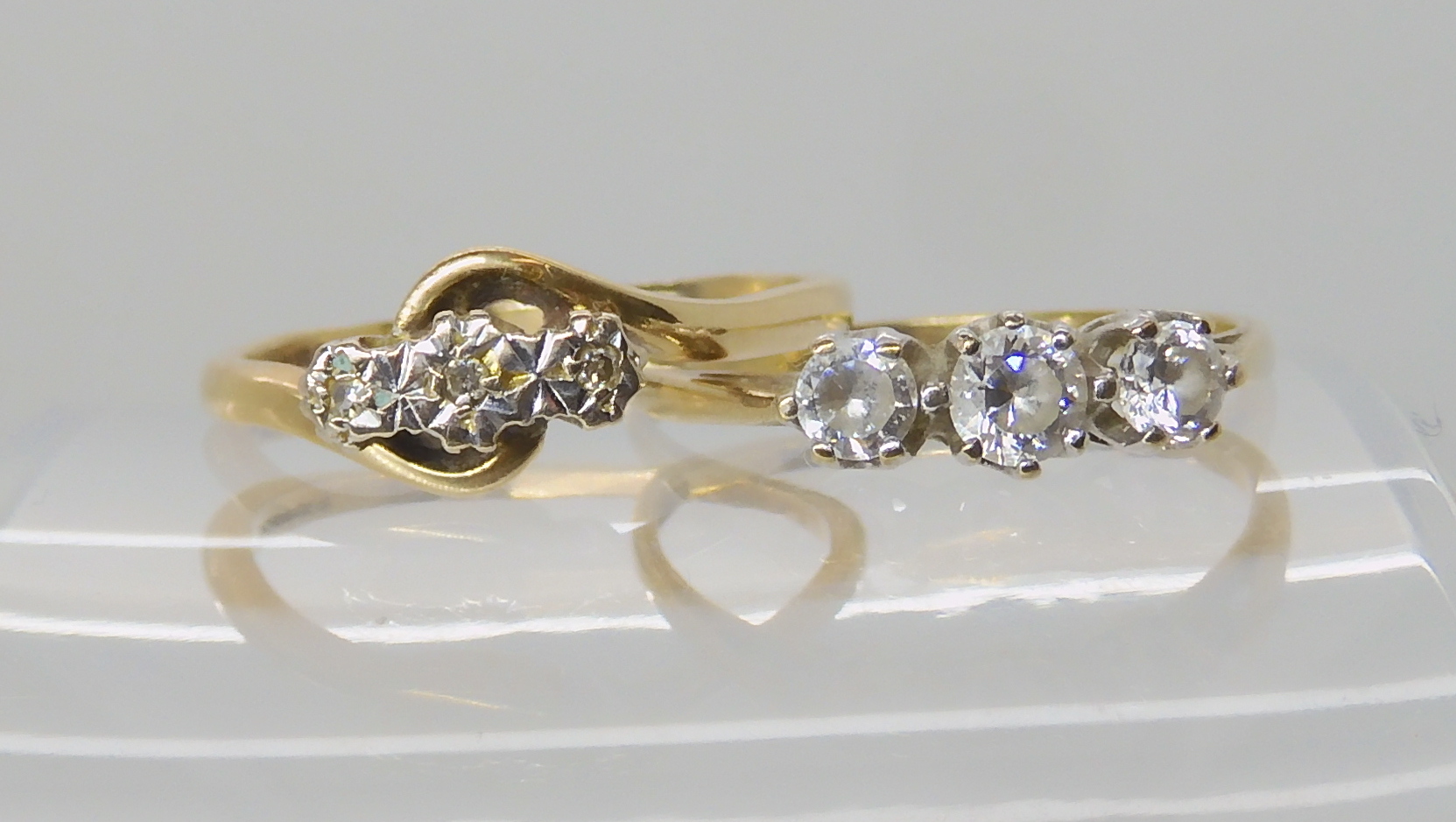 An 9ct gold three stone illusion set diamond ring, size P, together with a 9ct three clear gem set