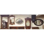 A carved oak overmantle mirror, two oval wall mirrors and a Georgian style oak wall mirror(4)