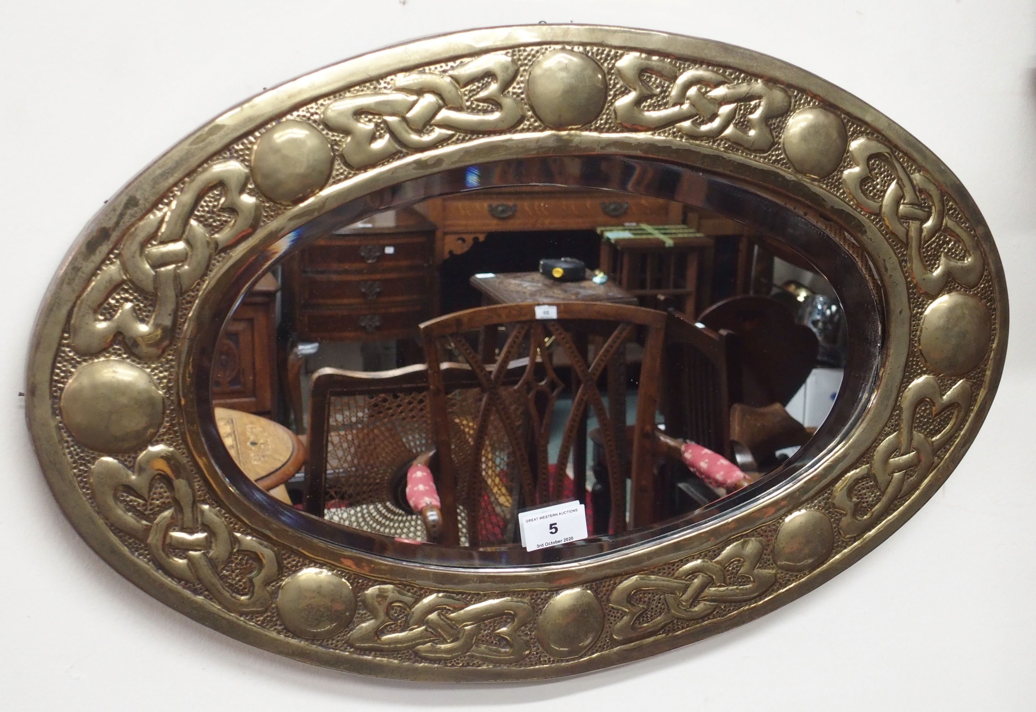 A brass Arts and Crafts oval mirror, 38cm x 60cm Condition Report: Available upon request