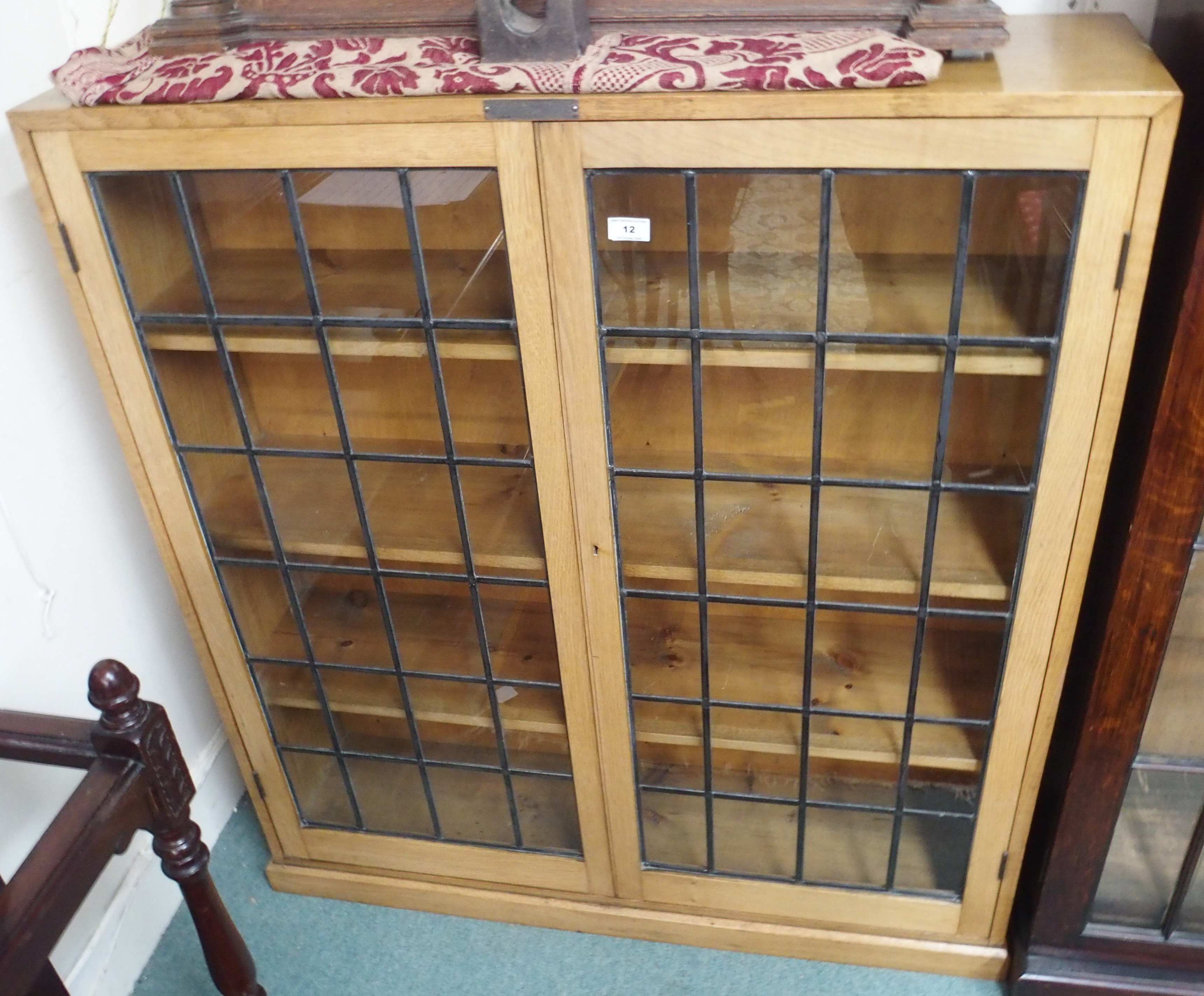 A light oak bookcase with leaded glass doors, 118cm high x 108cm wide Condition Report: Available