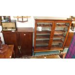 A mahogany two door glazed bookcase on turned legs, 150cm high x 130cm wide and a two door