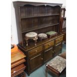 A reproduction oak dresser with open shelves over a base with three drawers over three cupboard