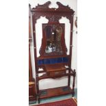 A carved mahogany hat and coat stand with mirror back and blue tiles, 230cm high x 96cm wide