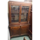 A mahogany bookcase with leaded and stained glass doors over a base with two drawers over two
