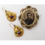 A pair of bright yellow metal garnet set earrings weight 3.8gms and a gold plated swivel locket back