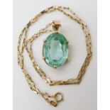 A green blue glass gem in a yellow metal pendant mount together with a 9ct chain length 50cm, weight