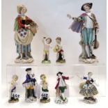 A pair of Naples figures of a couple, she holding a basket of flowers, him a mandolin, together with