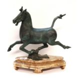 A bronze model of a horse running, upon wooden base, 33cm long Provenance - The Estate of the late